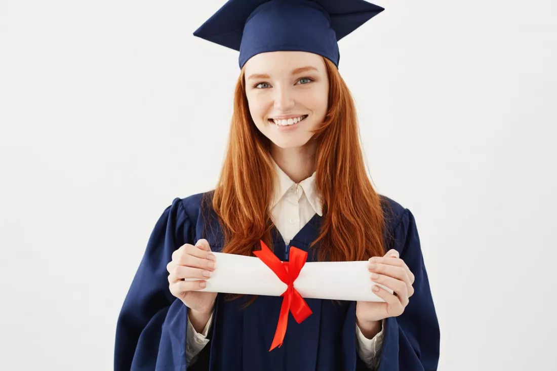 Una joven graduada con su título en la mano